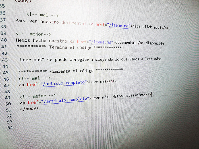 Una foto en primer plano de una pantalla de computadora que muestra cómo crear enlaces válidos y accesibles en código HTML con comentarios y etiquetas ancla en un editor de texto.